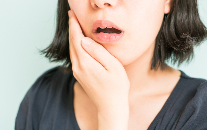 歯に痛みを感じる女性