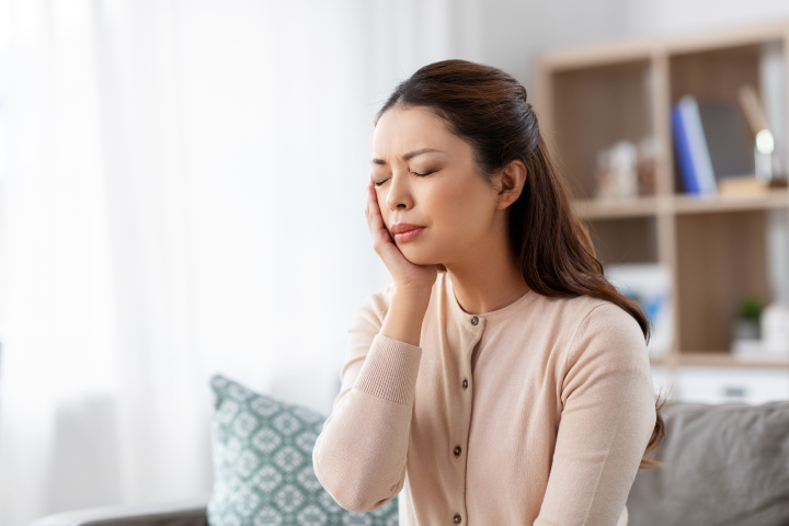 根管治療後に痛みを感じる女性