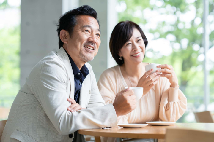 抜歯後にインプラントを入れた男性がカフェで楽しむ様子