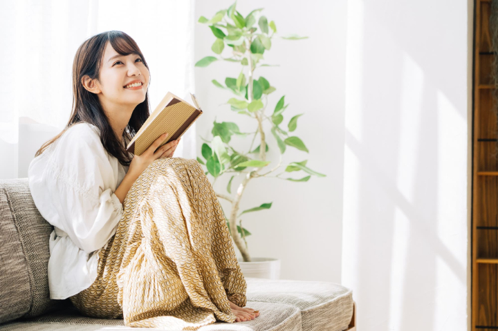 ソファーで読書する女性
