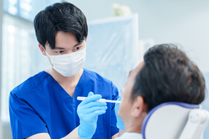 インプラントを長く使い続けるために定期的に歯科検診にかかる患者