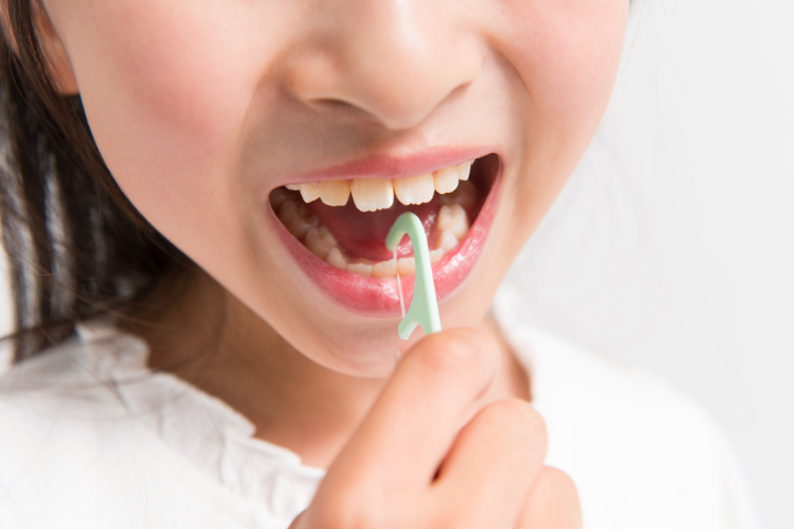 デンタルフロスを使用してケアをする女の子