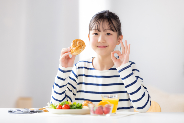 食べ物に注意しながら食事をする矯正中の女の子