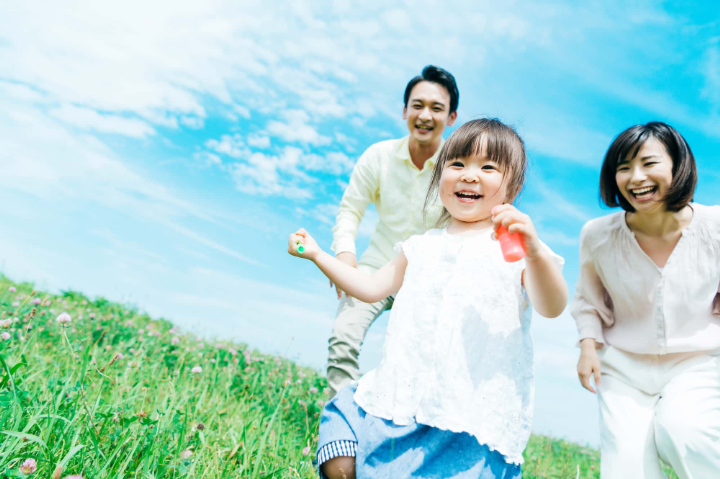 草原を走る笑顔の親子