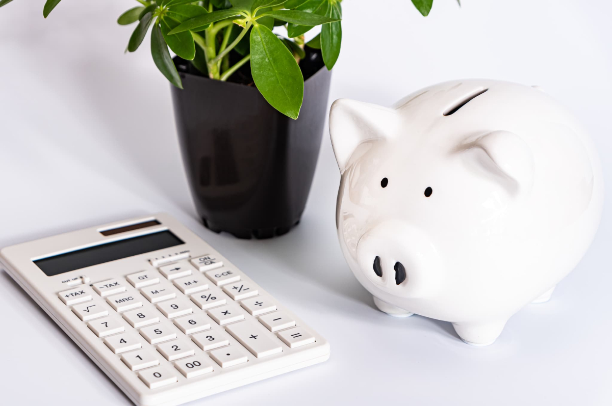 出っ歯の矯正にかかる費用を示す計算機と豚の貯金箱