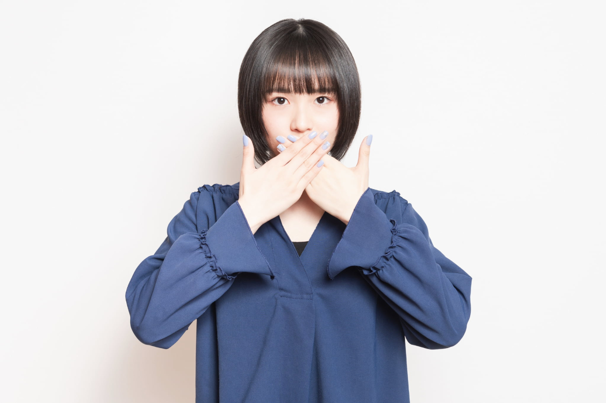 出っ歯がコンプレックスになって口元を隠す女性