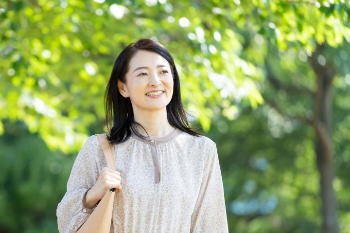 欠けたセラミックの歯が修理できて笑顔で散歩する女性