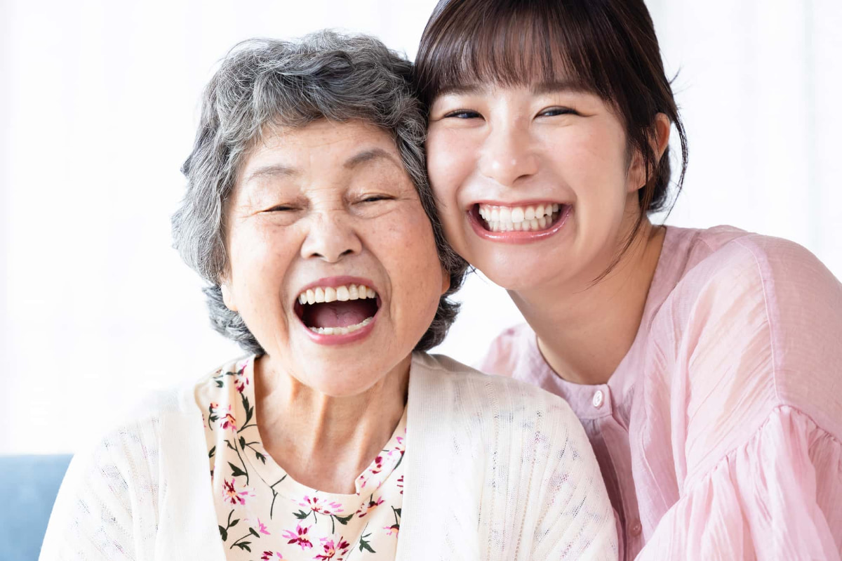 奥歯をインプラントにして満足して孫と笑い合うシニア女性